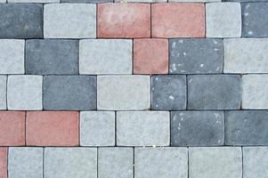 Texture of gray rectangular concrete stone paving slabs on the road with seams. The background photo