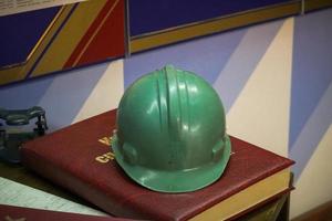 Green plastic safety helmet for the worker. Protective helmet to protect the head of people operating in hazardous conditions at the factory photo