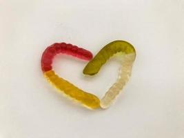marmalade worms. gelatinous worms, multi-colored intertwined in the shape of a heart. bright and tasty gelatinous high-calorie dessert. cooking photo