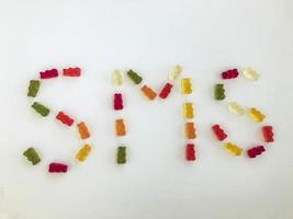 letter from multi-colored gummy bears. Letter S and M made from gelatinous candies on a white matte background. edible SMS word. mouth-watering vitamin word. sending messages photo
