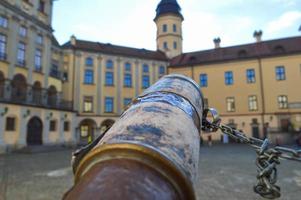 A look from an old ancient spyglass on a European medieval tourist building, a castle, a palace with a spire and a tower photo