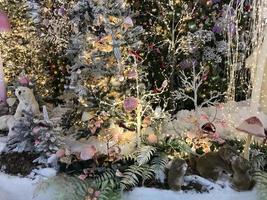 New Year's decorations for the shopping center. artificial Christmas trees with lighting. next to them are cute polar bears, squirrels and ferrets. artificial animals celebrate new year photo