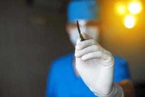 Plastic Doctor with a scalpel in his hand starts to operate. Professional surgeon in the operating room photo