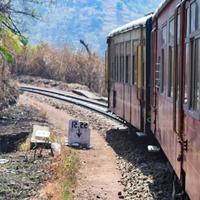 Toy Train moving on mountain slopes, beautiful view, one side mountain, one side valley moving on railway to the hill, among green natural forest. Toy train from Kalka to Shimla in India, Indian Train photo