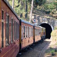 Toy Train moving on mountain slopes, beautiful view, one side mountain, one side valley moving on railway to the hill, among green natural forest. Toy train from Kalka to Shimla in India, Indian Train photo