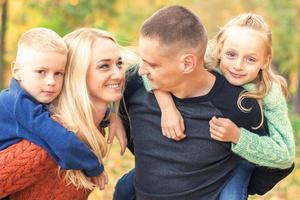 Portrait of young family in autumn park photo