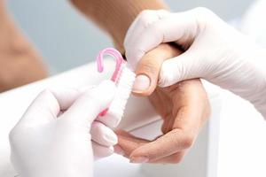 Manicurist removing dust from nails photo