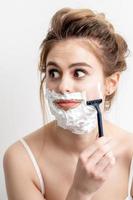 Woman shaving her face by razor photo