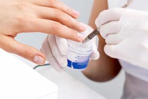 Human hands covering clear varnish on female nails photo