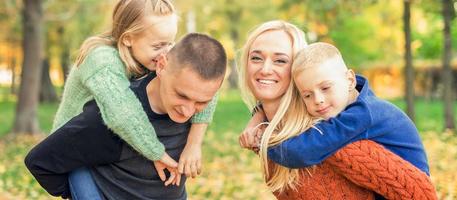 Portrait of young family in autumn park photo