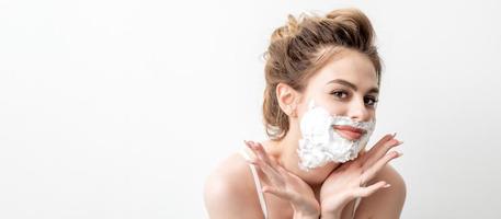 Woman with shaving foam on her face photo