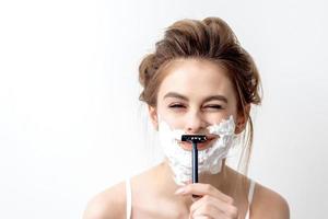 Woman shaving her face by razor photo