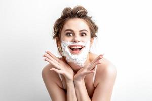 Woman with shaving foam on her face photo