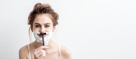 Woman shaving her face by razor photo