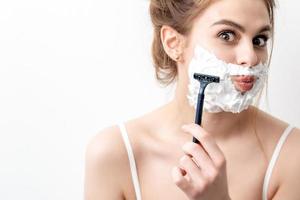Woman shaving her face by razor photo
