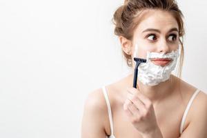 Woman shaving her face by razor photo