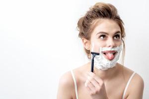 Woman shaving her face by razor photo