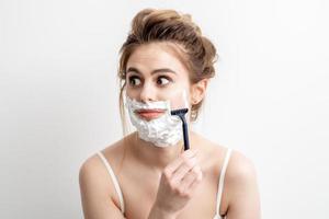 Woman shaving her face by razor photo