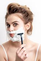 Woman shaving her face by razor photo