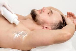 Master depilation pouring talcum powder on armpit photo