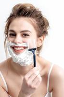 Woman shaving her face by razor photo