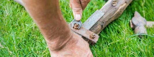 Elderly man twists the nut by wrench photo