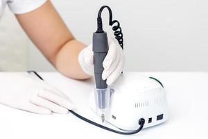 Electric manicure machine in manicure master hand photo