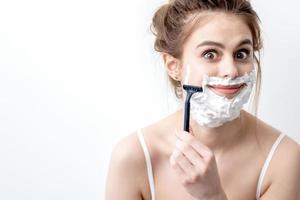 Woman shaving her face by razor photo