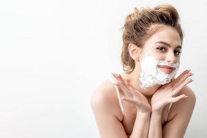 Woman with shaving foam on her face photo