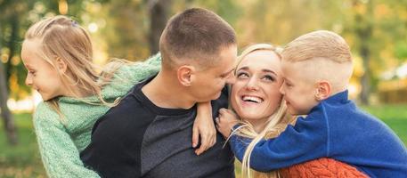 Portrait of young family in autumn park photo