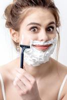 Woman shaving her face by razor photo