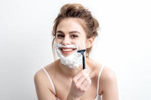 Woman shaving her face by razor photo