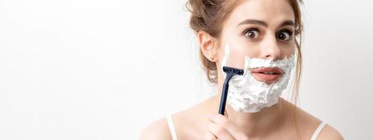 Woman shaving her face by razor photo