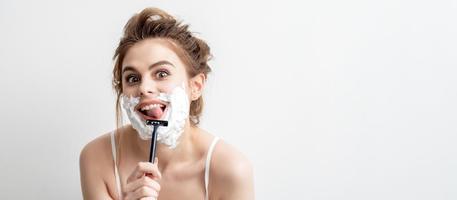 Woman shaving her face by razor photo