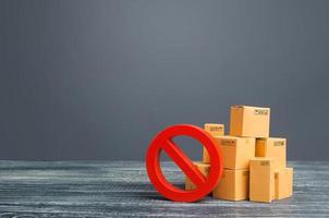 Cardboard boxes and red prohibition symbol NO. Out of stock. Embargo trade wars. Overproduction or scarcity. Restriction on import, ban on export of dual-use goods to countries under sanctions. photo