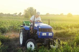 agricultor en un tractor trabaja en el campo agrícola. ganadería, agricultura. simplificar y agilizar el trabajo con tecnología y máquinas. agricultura y tierras de cultivo. cosechando papas. cosecha de patatas en otoño. foto