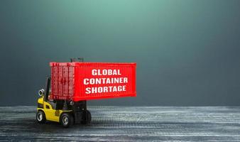 Global container shortage and a forklift. Problems of the international freight transport system. Imbalance, high prices for the transportation of goods. Consequences of economic slowdown. photo