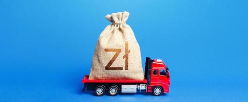 Truck is carrying a big polish zloty money bag. Anti-crisis measures of government. Great investment. Attracting large funds to the economy for subsidies, support and cheap soft loans for businesses. photo