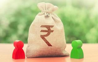 Indian rupee money bag and a deal between two persons. Business lending, leasing. Tender competitiona contract. Trade agreement. Negotiation process dealings. Dispute solution. Finance surety promise photo