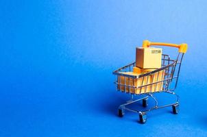 carrito de supermercado con cajas, mercancía. el concepto de compra y venta de bienes y servicios, comercio por Internet, compras en línea, comercio y facturación. importación y exportación, poder adquisitivo. foto