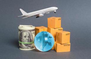 A stack of boxes, airplane a bundle of dollars and a blue planet earth globe. World trade and commodity exchange. commerce traffic trading balance. Import, export, transit of products. photo