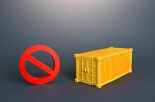 Cargo container and red NO prohibition sign. Logistic crisis in sea cargo transportation. Shipping container shortage concept. Imbalance in global trade. Impossibility of exporting goods photo