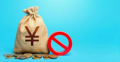 Yuan Yen money bag and red prohibition sign NO. Confiscation of deposits. Termination funding for projects. Monitoring suspicious money flows. Monetary restrictions, freezing seizure of bank accounts. photo