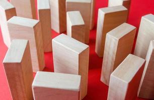 Wooden blocks on a red background. Concept of a maze labyrinth of wardrobes or dense urban construction. View from above. Barriers and obstacles. Objects and structures. photo