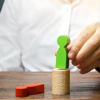 The man changed the red figure to the green one at the post. firing staff. Head Offset. Business optimization, replacement of key employees with loyal ones. Change of power. Anti corruption photo