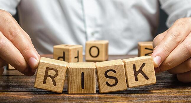 The man carelessly raises the word Risk. High risks in business, fragile balance and insecurity. Caution and anticipation of possible problems and shocks. Planning and action strategy. Analytics photo