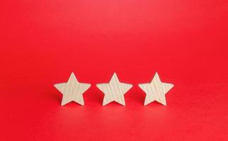 Three stars on a red background. Rating evaluation concept. Service quality. Buyer feedback. High satisfaction. Good reputation status. Popularity rating of a restaurant, hotel or mobile applications. photo