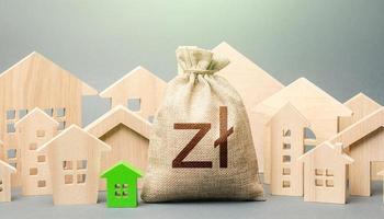 Polish zloty money bag and a city of house figures. Investments. City municipal budget. Property tax. Development, renovation of buildings. Buying real estate, fair price. Cost of living. photo