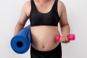 Overweight women are beginning to exercise with a yoga cushion and dumbbells. Health care concept. photo