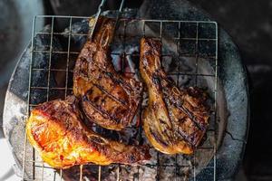 The top view of the pork is grilling on a charcoal grill. photo